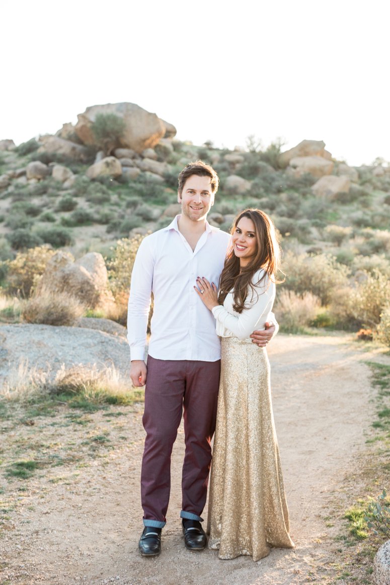 What to wear for family pictures outside | couple standing in desert, woman in gold sequin skirt | lifewithmar.com 